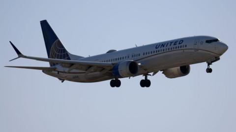 A United Airlines plane flies in the air