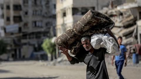 People pictured fleeing to the southern regions in Gaza with their belongings 