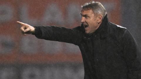 Paul Simpson points animatedly on the touchline