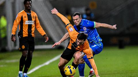 Adam Mayor of Cambridge United challenges Shaun Whalley of Accrington Stanley during the League Two match
