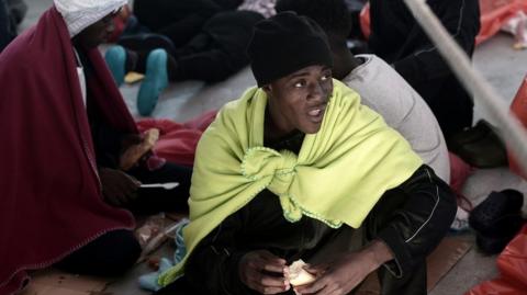 A man eats food onboard the French rescue ship Aquarius carrying migrants to Spain