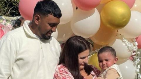 A man and a woman holding a baby girl