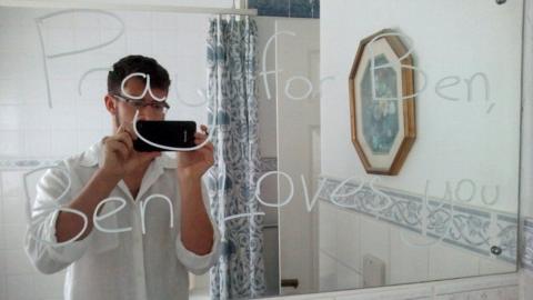 Ben Field in front of mirror message that reads "pray for Ben, Ben loves you".