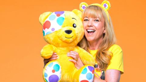 Sara Cox holding a Pudsey the bear toy