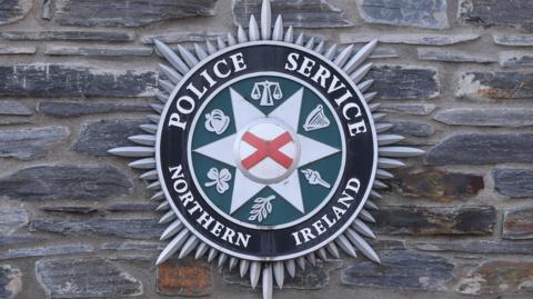PSNI Crest on a a stone wall