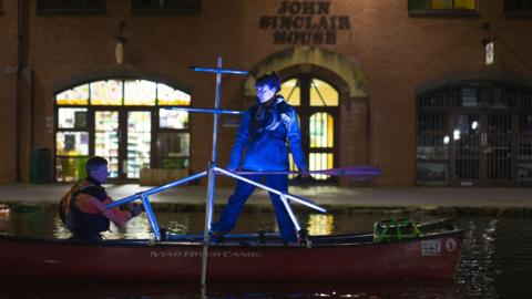 Performers on canoes rehearsing