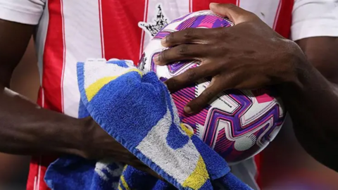 A close-up of Brentford's Michael Kayode drying the ball with a towel