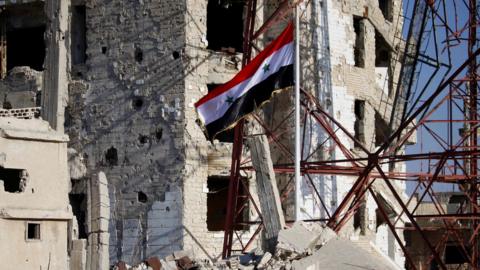 Syrian national flag flies in the previously rebel-held part of Deraa city, Syria (12 July 2018)