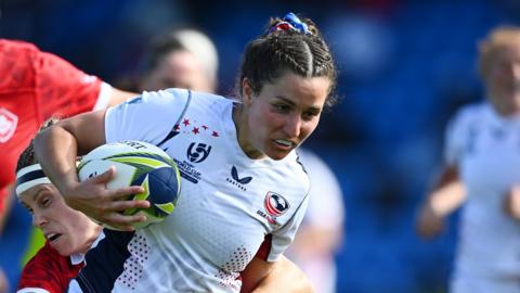 Tess Feury attempting to break a tackle while playing for the United States