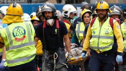 Emergency workers evacuate an injured worker following a building site collapse at Madrid's Ritz Hotel