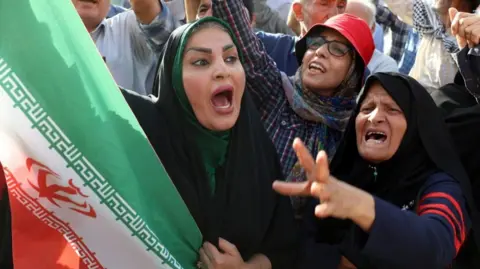 An Iranian woman holding a national flag shouts slogans during an anti-US and anti-Israel demonstration in Tehran, Iran, 22 June 2025