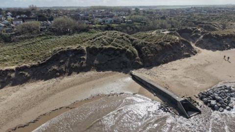 Aerial shot of a large sanddune and a beach.