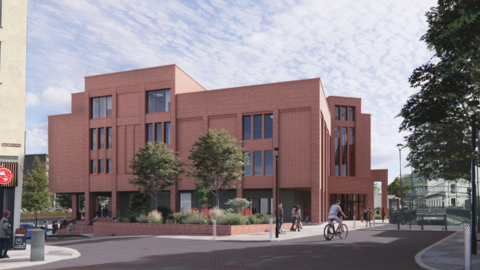 A computer generated image of a red brick building with several windows of different sizes. It sits in the middle of a square with trees and plants in planters and people walking and cycling past it.