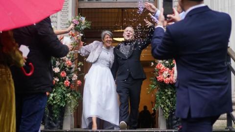 Ian Elliot, 54, and Paula Diaz, 50, following their civil partnership cermony at at Old Marylebone Town Hall