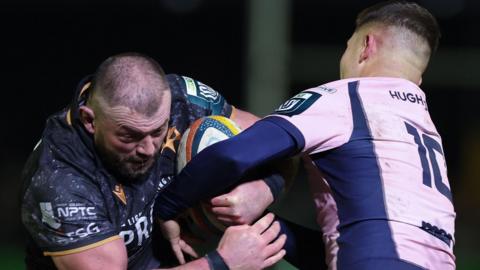 Sam Parry of Ospreys (L) takes on Callum Sheedy of Cardiff 