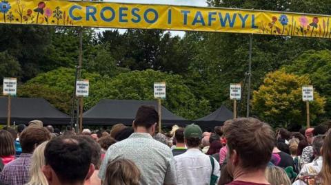 The backs of a large number of people queuing to gain entry to the Tafwyl festival in Cardiff on Saturday