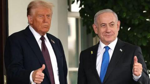 Donald Trump and Benjamin Netanyahu standing next to each other, both gesturing with thumbs up. Both are in a black suit. Trump has a dark red tie, Netanyahu wears a blue one.