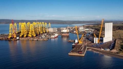 A general view of the Port of Nigg from above showing machinery on platforms in the water and a number of boats moored nearby.