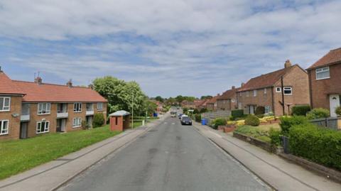 View down a suburban street with homes on either side of a road