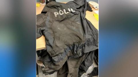 A burned police PPE uniform being worn by officers at the time