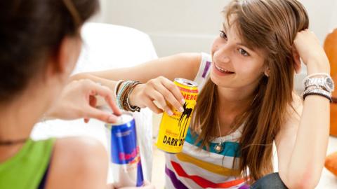 Teenage girls drinking energy drinks