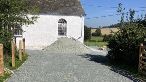 A mound of gravel outside the chapel