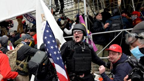 A man calls on people to raid the building as Trump supporters clash with police on 6 January