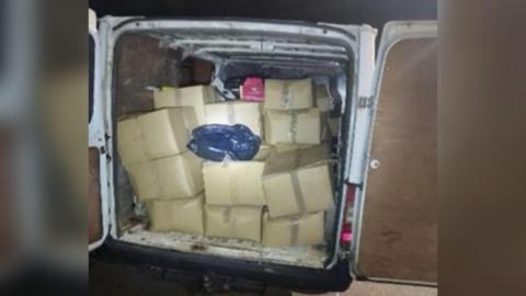 A police image of more than 10 brown boxes in the back of a white van