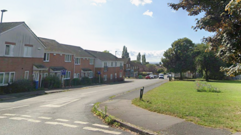 Wollaton Road, Chaddesden, a residential street with an area of grass land to the right 