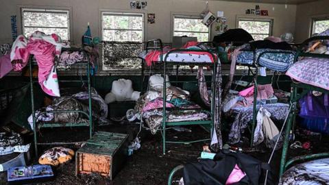 A view inside of a cabin at Camp Mystic showing destroyed bunk beds
