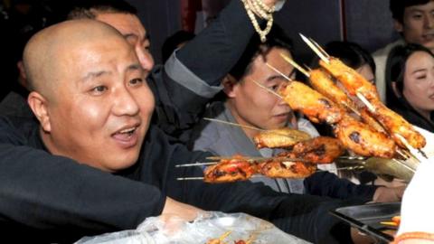 Tourists picking out meat skewers at a barbecue joint in Zibo