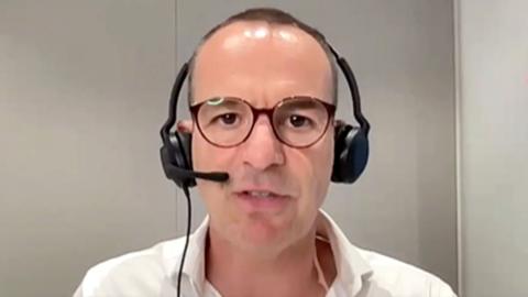 Martin Lewis wearing a headset and talking on his podcast.