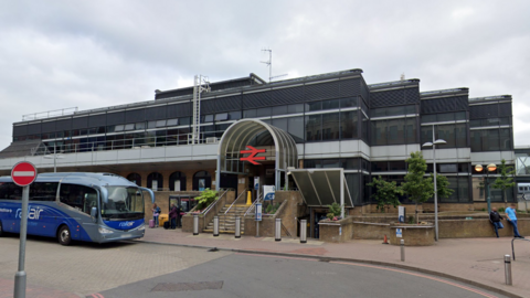 A general view photo of Reading station, with a blue coach to the left 