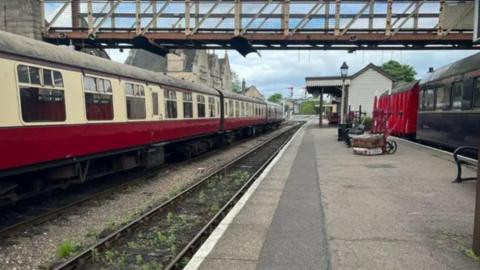 Heritage railway station- with a red and white train on the tracks 