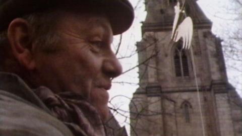 Fred Dibnah stands in front of Bury Cathedral.