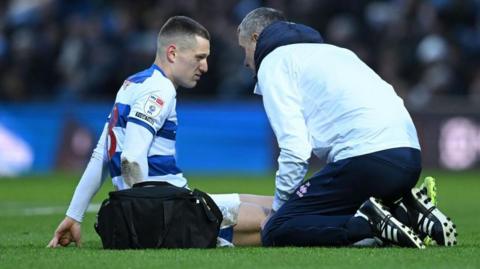 QPR forward Zan Celar receiving treatment on the pitch against Norwich City