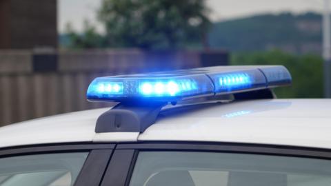 A stock image of blue lights flashing on top of a police car