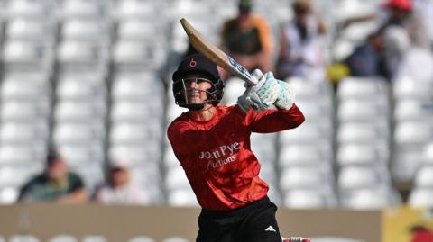 Australian Charli Knott playing for The Blaze, batting with a navy helmet on