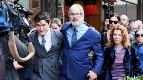 John Jarratt (centre) with supporters after the verdict in Sydney on Friday