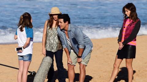 Filming on a beach for Home and Away