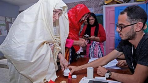 A Tunisian woman casts her vote at a polling station during presidential elections in the capital Tunis on September 15, 2019