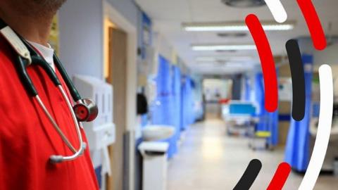 Inside of a hospital with a member of staff wearing a stethoscope around his neck