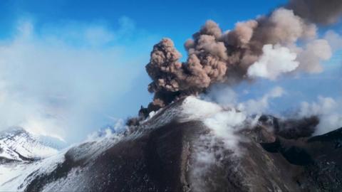 Plumes of smoke emerging from a snowy Mount Etna