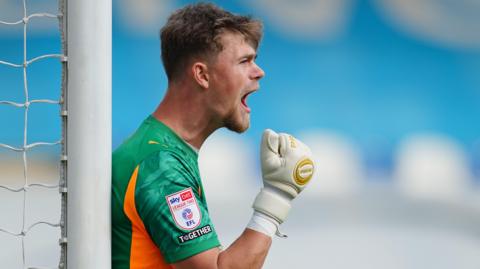 Crewe goalkeeper Tom Booth shouts at his defence during a game