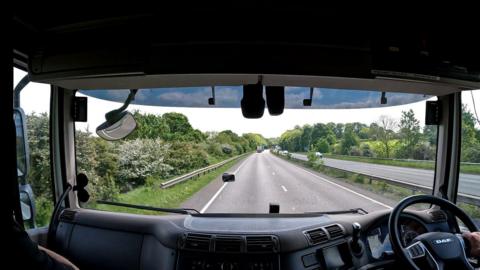 The image shows a road from the perspective of someone inside a lorry.