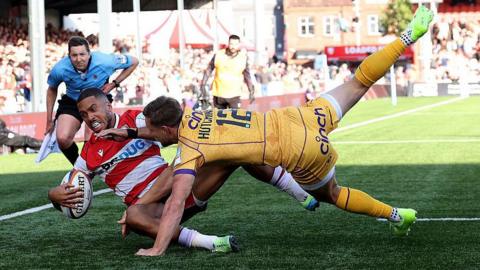 Northampton Saints player Rory Hutchinson tackles Gloucester's Ben Loader to prevent a try.