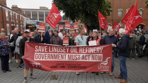 A crowd of people holding banners and flags calling for the Lindsey Oil Refinery to be saved.