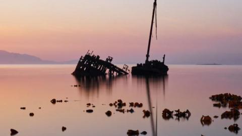 A sunken boat in a calm sea at night