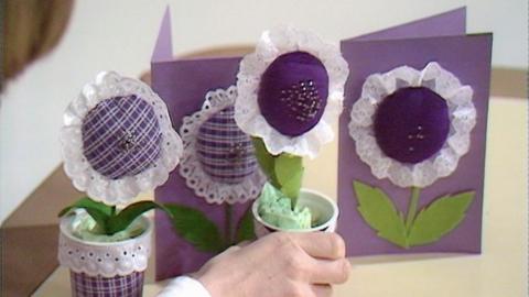 Handmade pin cushions in the shape of flowers on cards.