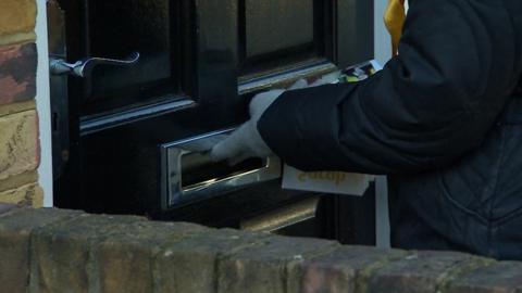 Candidate putting by-election leaflets through a letterbox